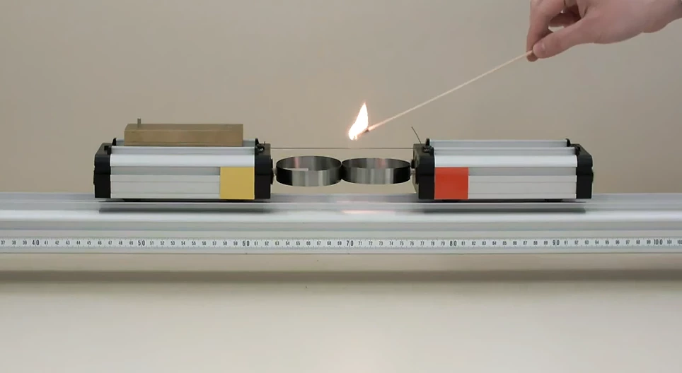 ばねで互いに押し出される異なる質量の小型車二台