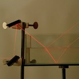 انكسار وانعكاس ضوء الليزر في حدود الهواء و الماء، و الماء و الزجاج.